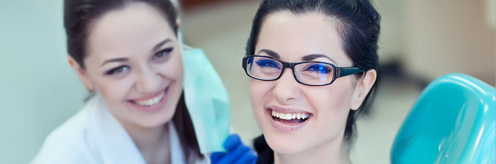 A beautiful young lady with her dentist smiling